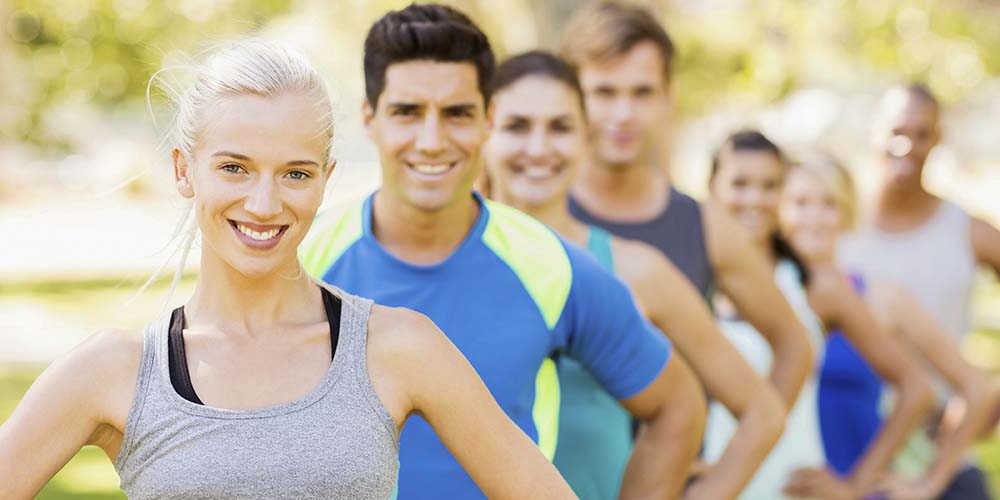 Males and females in active wear smiling at the camera