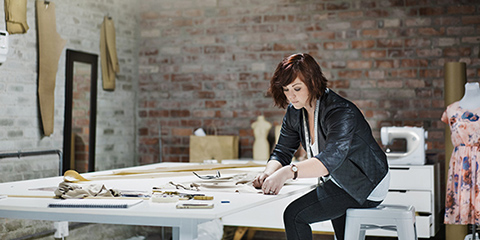 A photo of fashion designer working at table.