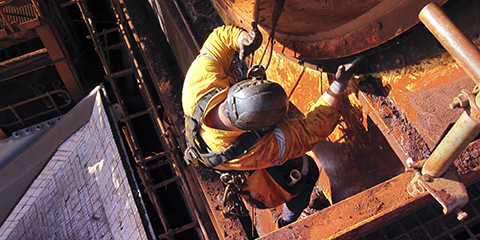 Rope access industrial technician miner fitters, boilermaker wearing fully safety harness, abseiling working maintenance inspecting cleaning chute roller isolated mining iron ore construction Perth