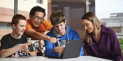 Students gathered around a laptop